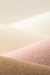 Close-up detail shot of soft ribbed knit fabric texture, fine craftsmanship and comfortable material.