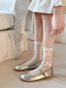 Sweet Japanese style mid-calf socks featuring cute pink bows and vertical stripes, detail shot.
