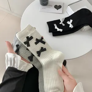 Detail view of cute bow decorated ribbed knit women mid tube socks in sweet Lolita style design.