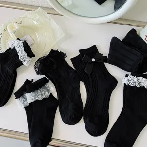 Chaussettes lolita noires en dentelle avec de jolis nœuds style gothique doux bas mode.