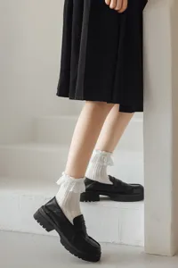 Gros plan détaillé de chaussettes mi-hautes blanches à volants en dentelle Lolita.