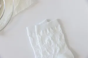 Detail des chaussettes Lolita en dentelle blanche, bas mi-longs kawaii a motifs floraux.