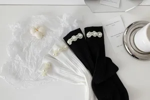 Primo piano dettagliato di calzini stile Lolita giapponesi con delicate perle in bianco e nero.