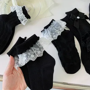 Gros plan détaillé de chaussettes Lolita noires japonaises avec bordure en dentelle blanche.