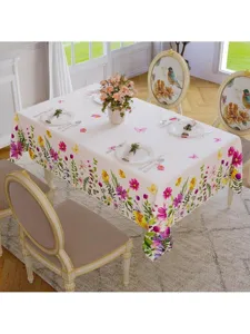 Vista detallada del mantel de primavera con flores coloridas y mariposas en la mesa del comedor.