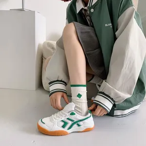 Detail shot of Japanese college style mid-tube socks featuring green stripes and clover embroidery.