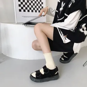 Vue détaillée de chaussettes unies confortables associées à des sandales noires élégantes.