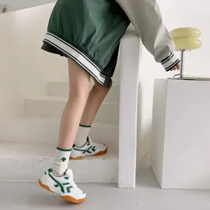 Green striped mid-tube socks with clover detail, Japanese college style fashion accessory.