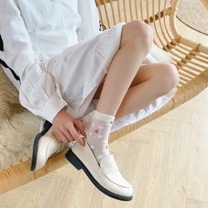 Cute white women mid-tube socks with sweet strawberry and floral print, soft mesh detail view.