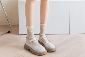 Close-up detail of sheer mesh summer socks with cute heart patterns and frilly lace cuffs.