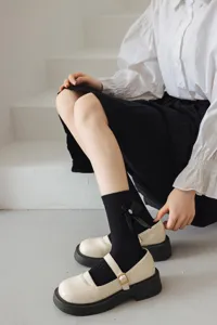 Vue détaillée de chaussettes mi-mollet noires style Lolita japonaise avec un nœud et perle.
