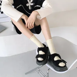 Gros plan détaillé de chaussettes mignonnes à bord roulé en beige doux pour un look quotidien.