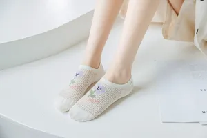 Close-up detail of breathable mesh boat socks featuring cute flower and letter patterns.