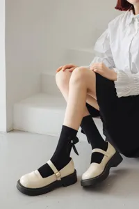 Chaussettes mi-basses noires à nœud mignon avec chaussures compensées beige clair.