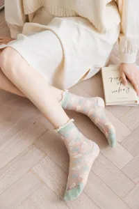 Detail shot of Japanese style sheer ruffle glass silk socks with cute cloud pattern and green trim.