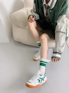 Green striped mid-tube socks detail shot showcasing cute Japanese style college fashion socks.
