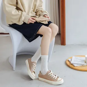 White cotton mid-calf socks for women featuring delicate knit patterns, perfect for casual wear.