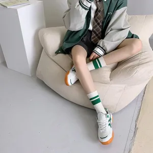 Green striped mid-calf socks detail shot, Japanese college style fashion accessory for women.