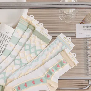 Close-up detail of sheer mesh cute pastel socks with sweet heart and grid patterns, soft style.