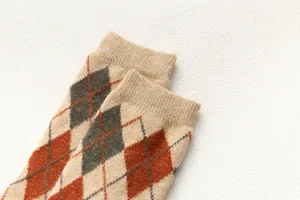 Nahaufnahme von Winter-Wollsocken mit Argyle-Muster, zeigt weiche Strickstruktur.