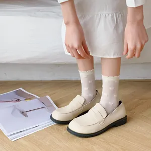 Close-up of cute Japanese style white mid-tube socks with bow patterns and stylish shoes.