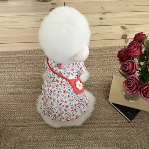 Detailed shot of cute small dog floral dress with mini bag accessory, cozy pet setup.