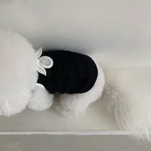 Detailansicht der schwarzen Hundeweste aus Strick für Haustiere, mit weißer Schleife.