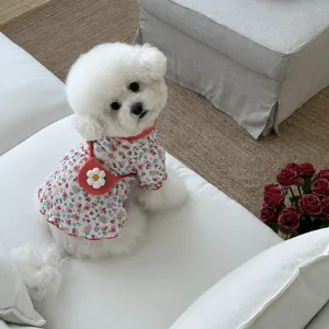 Close-up detail of cute floral pet dog dress with mini red bag accessory for small puppies.