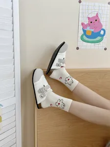Detail shot of cute cartoon bear socks and casual clog shoes, cozy bedroom background lifestyle.