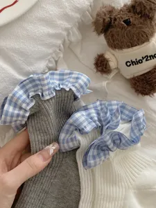 Gros plan de chaussettes côtelées pour femmes à revers à volants à carreaux et tissu doux.