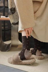 Vue détaillée de chaussettes en laine à motif chat, design vintage chaleureux hivernal.
