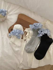Vue détaillée des chaussettes à volants vichy bleus montrant le joli design à double revers.