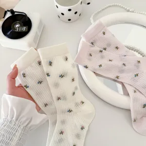 Detailansicht süßer Blumen-Netz-Mittelsocken in Weiß und Rosa, zart und atmungsaktiv.