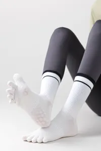 Non-slip five toe yoga socks with grip dots and striped cuffs for pilates and fitness.