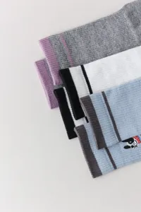 Close-up detail of knitted mid-tube socks featuring cute animal embroidery and stripes.