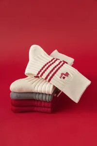 Detailed view of knitted mid-tube socks featuring cute snake embroidery and stripes.