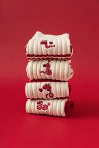 Detailed view of women's red and white knit mid-tube socks featuring cute zodiac snake embroidery.