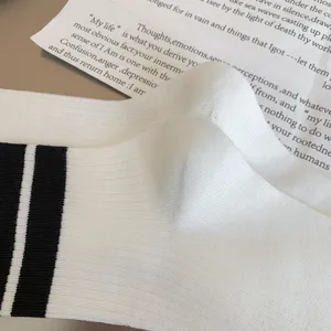 Classic white tube socks with black stripes, premium ribbed knit style for daily wear.