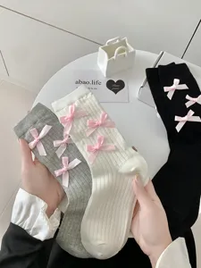 Close-up detail of cute Lolita style women mid-calf socks featuring sweet pink bow accents.