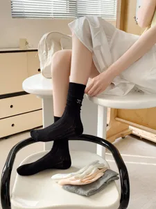 Detail view of black mesh sheer crew socks with sweet bow embroidery for women and girls.