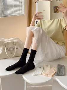 Detail view of sweet bow embroidered mesh mid tube socks, breathable spring summer wear.
