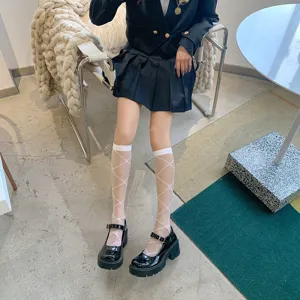Close-up shot of sheer white knee-high socks with diamond pattern paired with black shoes.