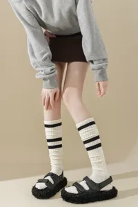 Detail view of striped slouch socks in thick knit, paired with chunky shoes for a stylish look.