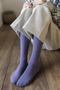 Close-up of purple winter thick terry socks worn on legs, cozy home scene styling, soft knit texture.