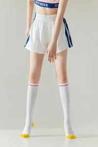 Women knee high sports socks with yellow toe and heel, fashion trendy slim long socks detail.