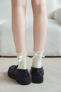 Vue détaillée de chaussettes mi-mollet japonaises mignonnes avec des nœuds et des volants.