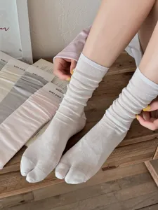 Detailed view of women's split toe white solid color thin breathable cotton socks.