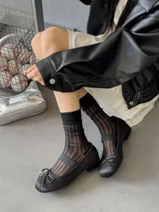 Sheer black striped socks paired with stylish black shoes, offering a trendy summer look.