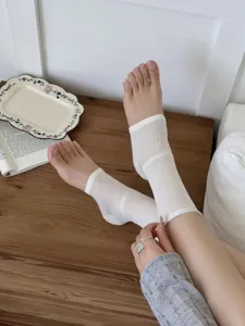 Detail view of white open-toe foot socks, lightweight summer hosiery and stylish accessory.