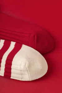 Detailed shot of knitted mid-tube socks in solid red and striped design, cozy winter socks.